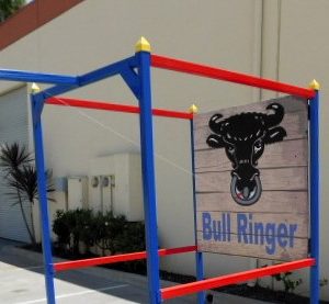 Side view of the bull -ringer carnival game - ring swings from rope towards hook to make it